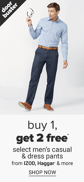 A man in a light blue dress shirt, navy pants and a brown belt and shoes. 